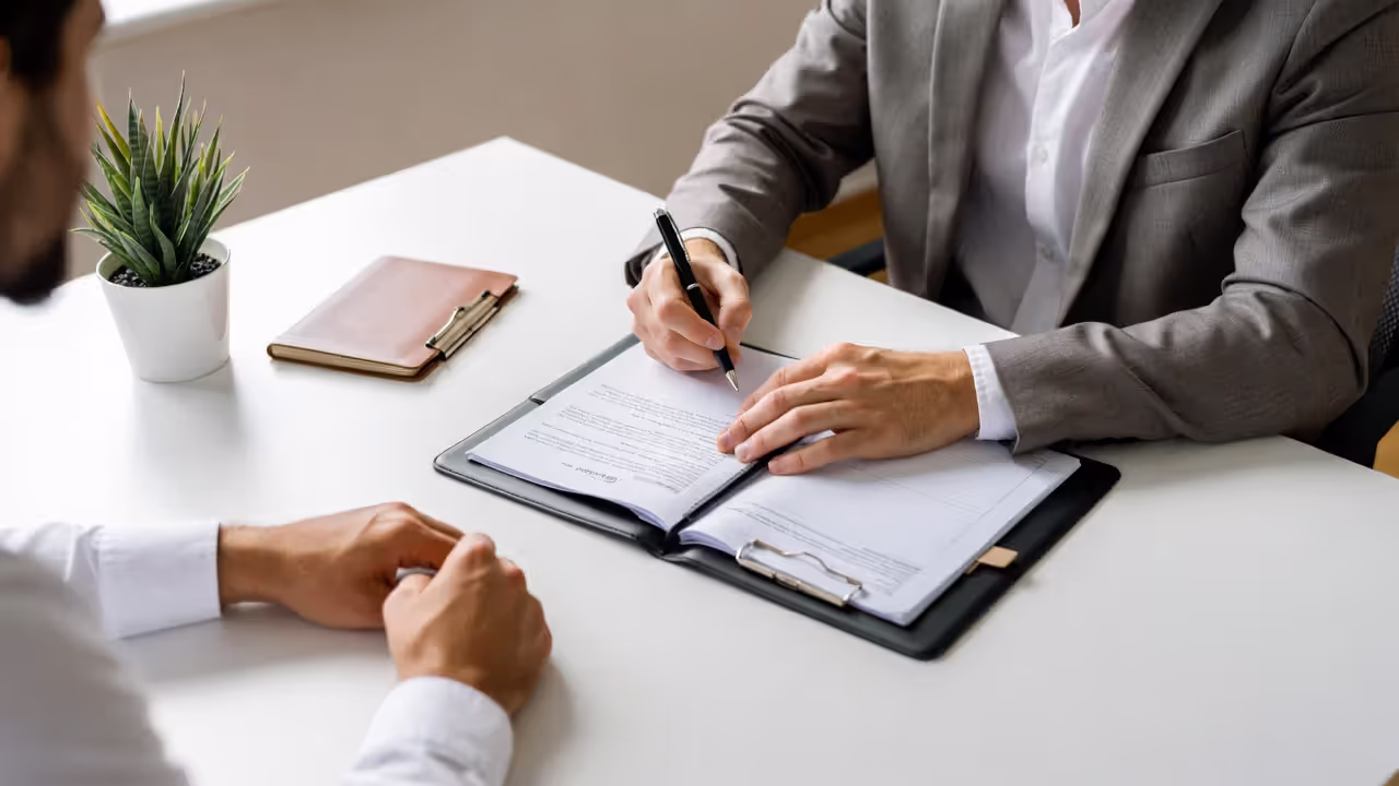 Client meeting with attorney discussing legal documents at office desk